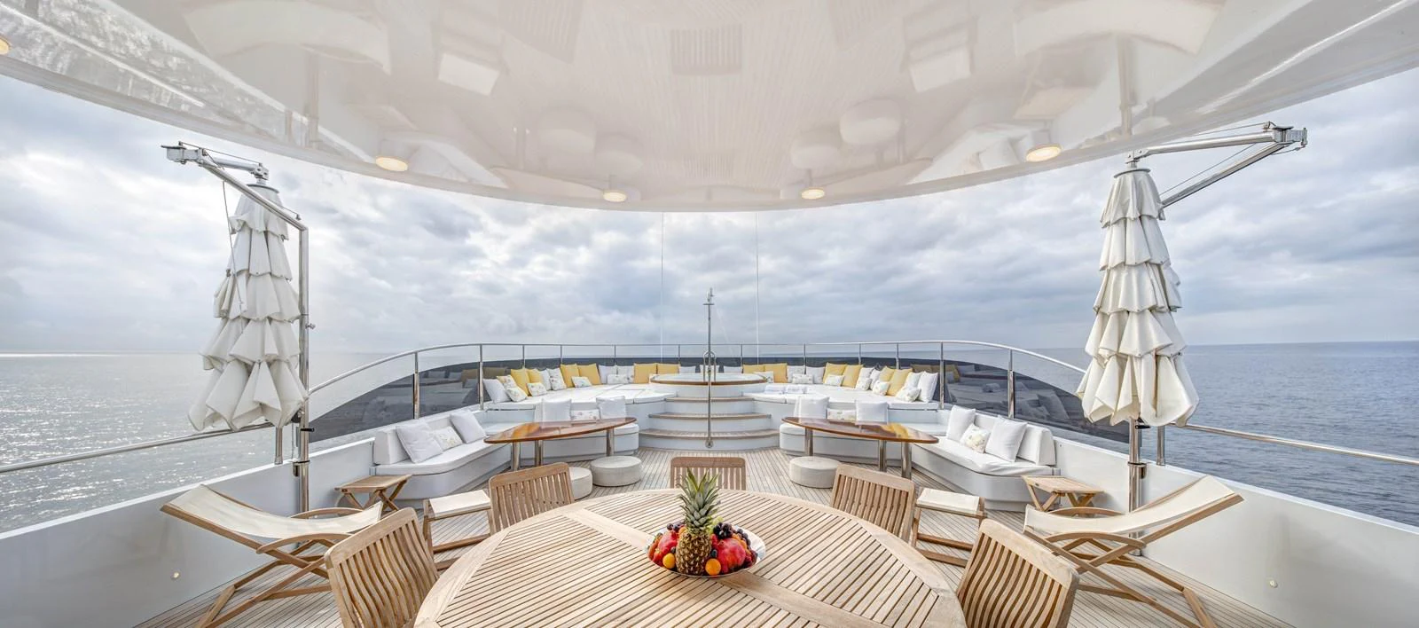 a large white boat with a table and chairs on a deck aboard BARON TRENCK Yacht for Charter