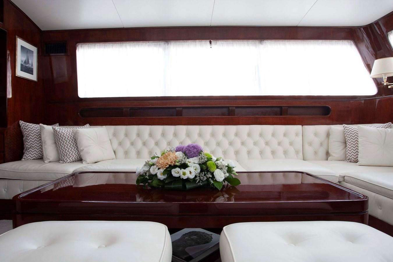 a room with a couch and a table with flowers on it aboard LAMADINE Yacht for Sale