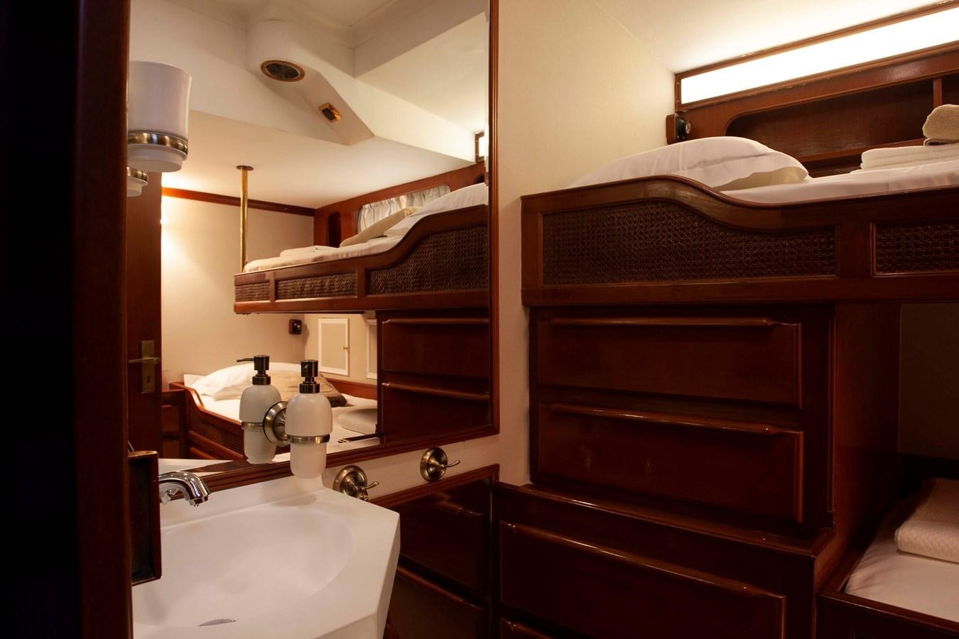 a wooden bunk bed next to a sink aboard LAMADINE Yacht for Sale