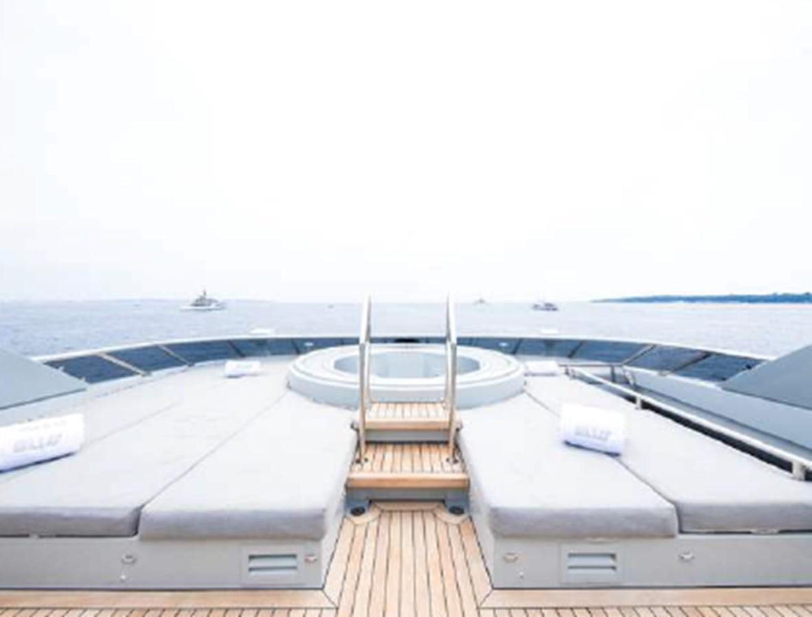 a deck with a railing and a boat on it aboard BLISS Yacht for Charter