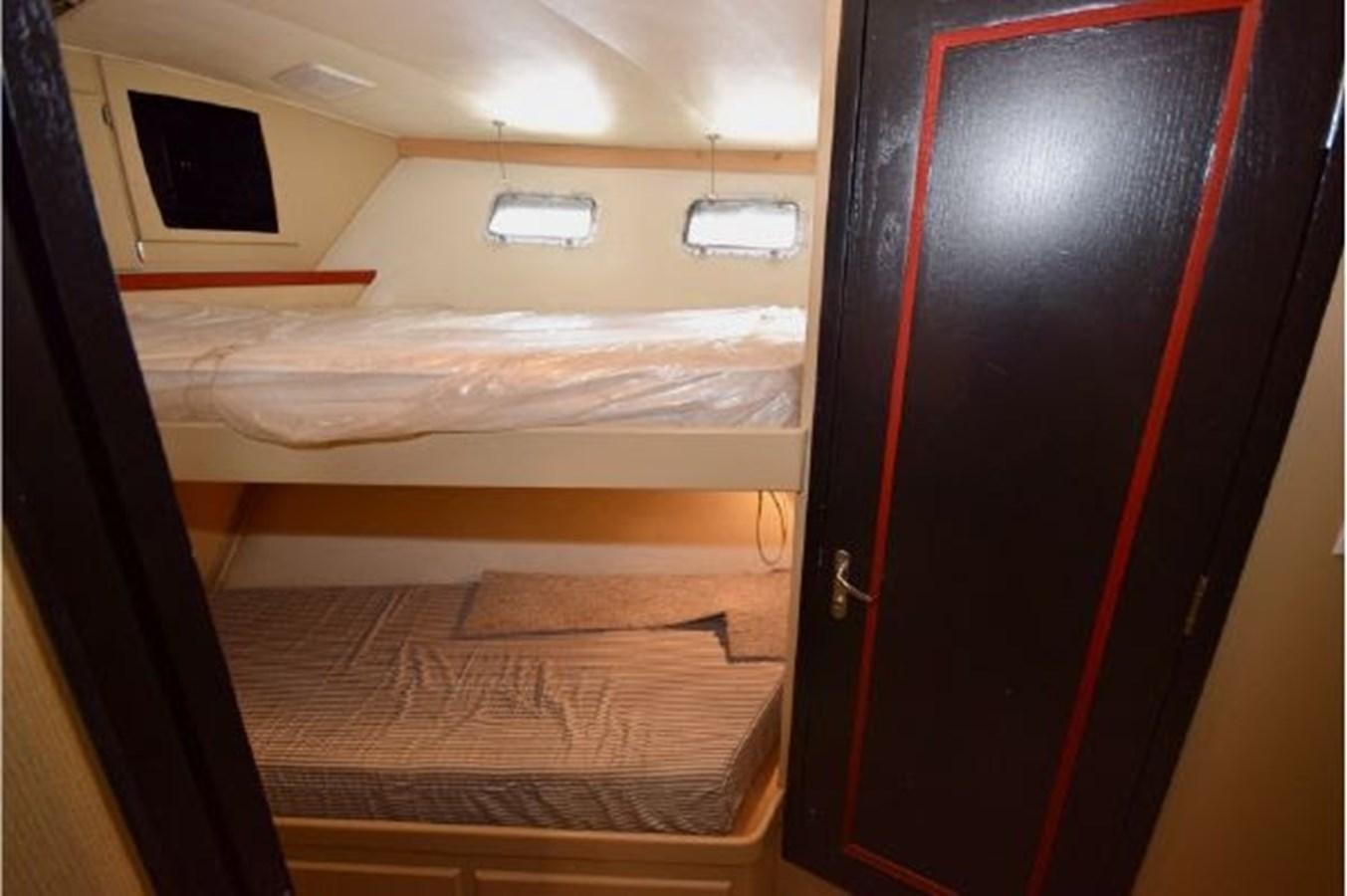 a closet with a bed and a television aboard MAC LL Yacht for Sale