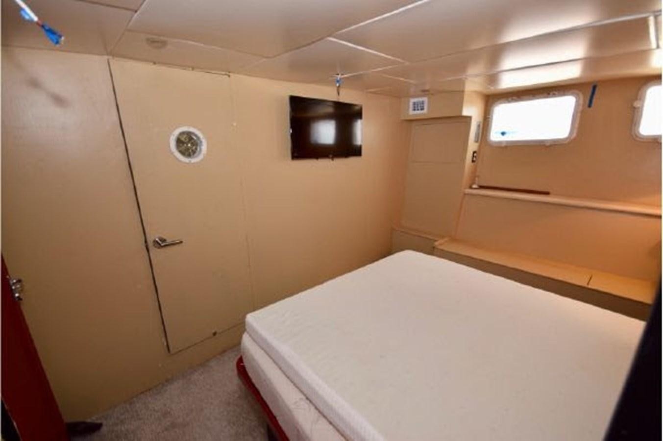a room with a bed and a television aboard MAC LL Yacht for Sale