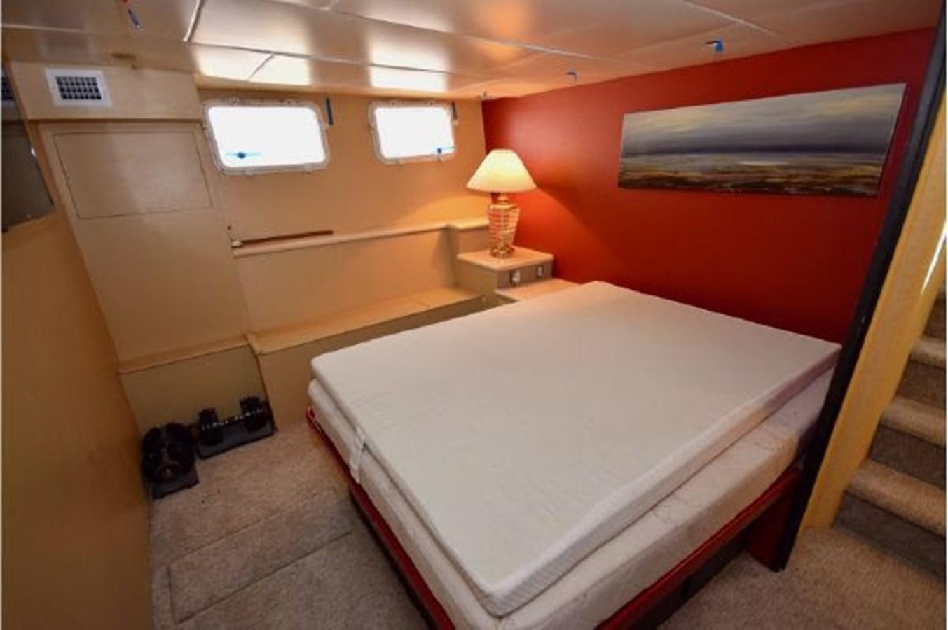 a room with a bed and a lamp aboard MAC LL Yacht for Sale