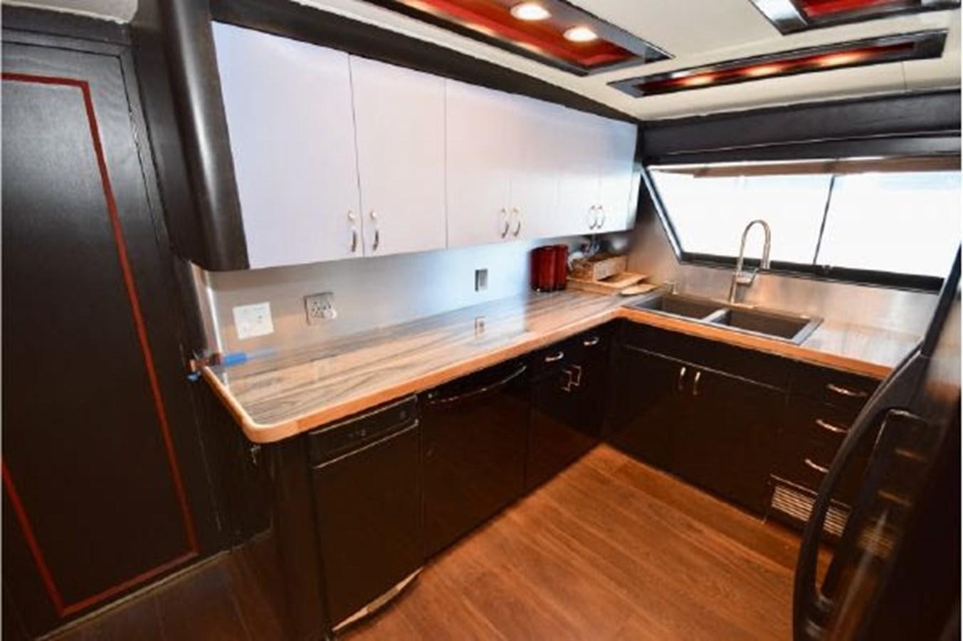 a kitchen with black cabinets aboard MAC LL Yacht for Sale