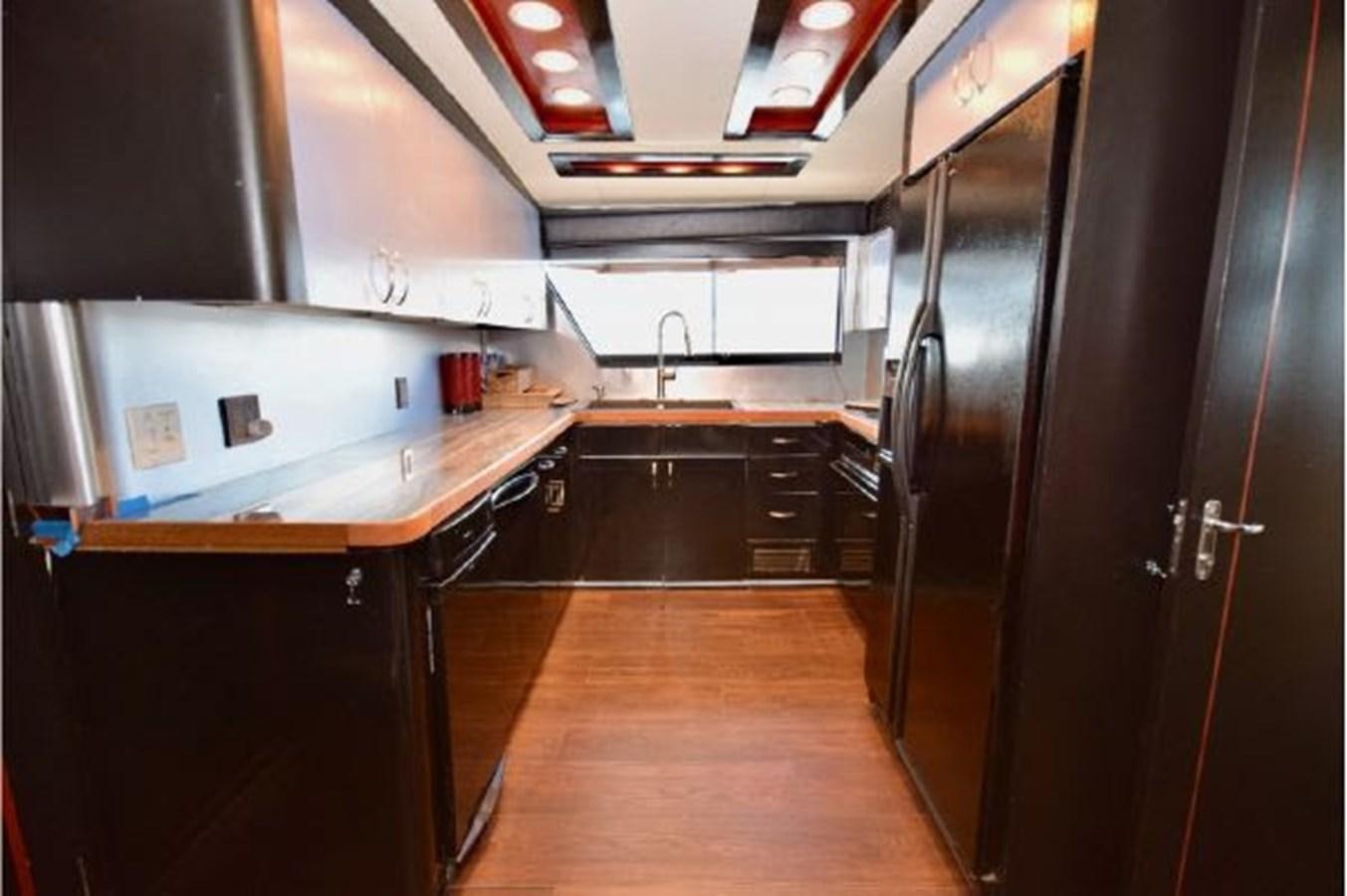 a kitchen with a large refrigerator aboard MAC LL Yacht for Sale