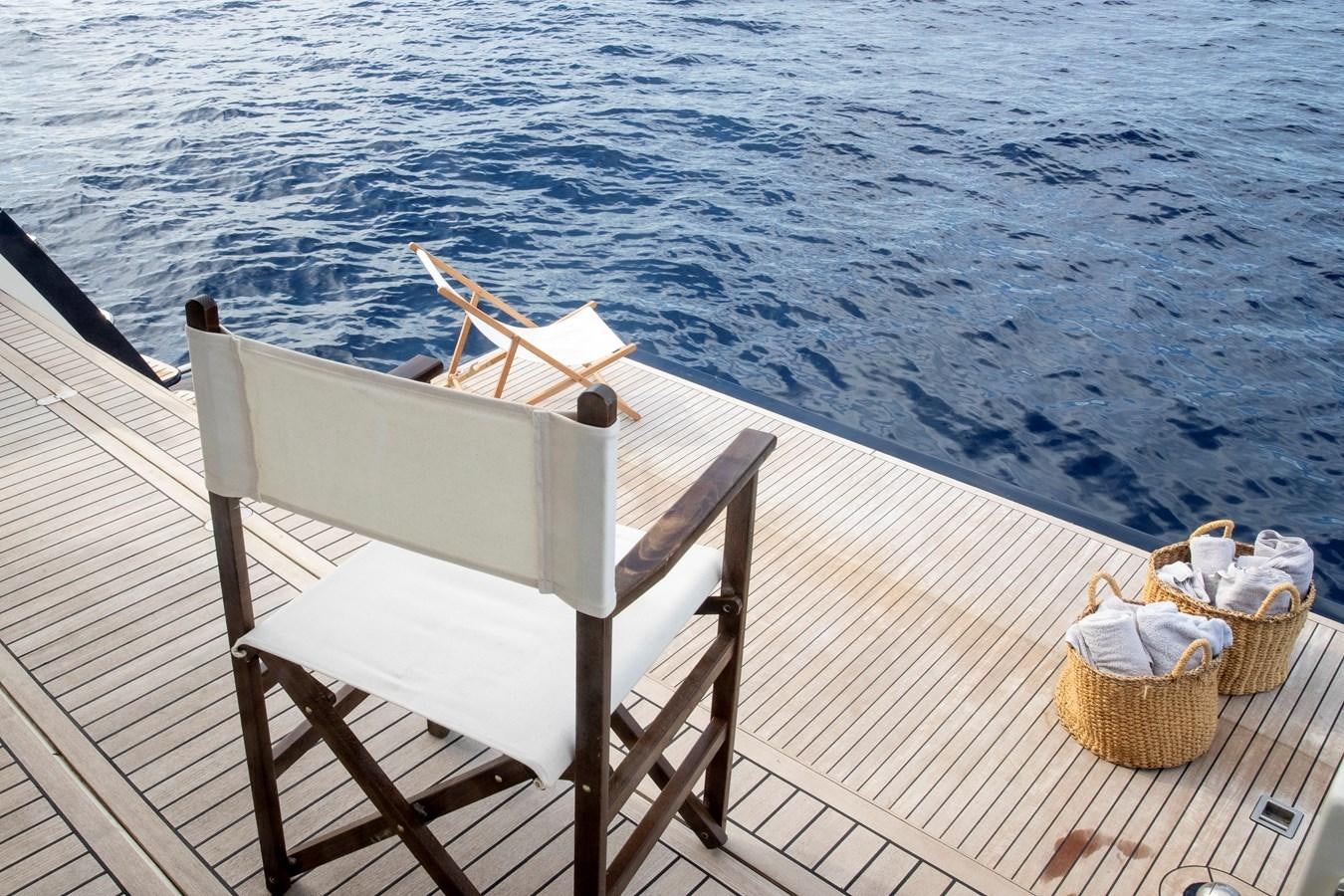 a chair on a deck aboard BIM Yacht for Sale