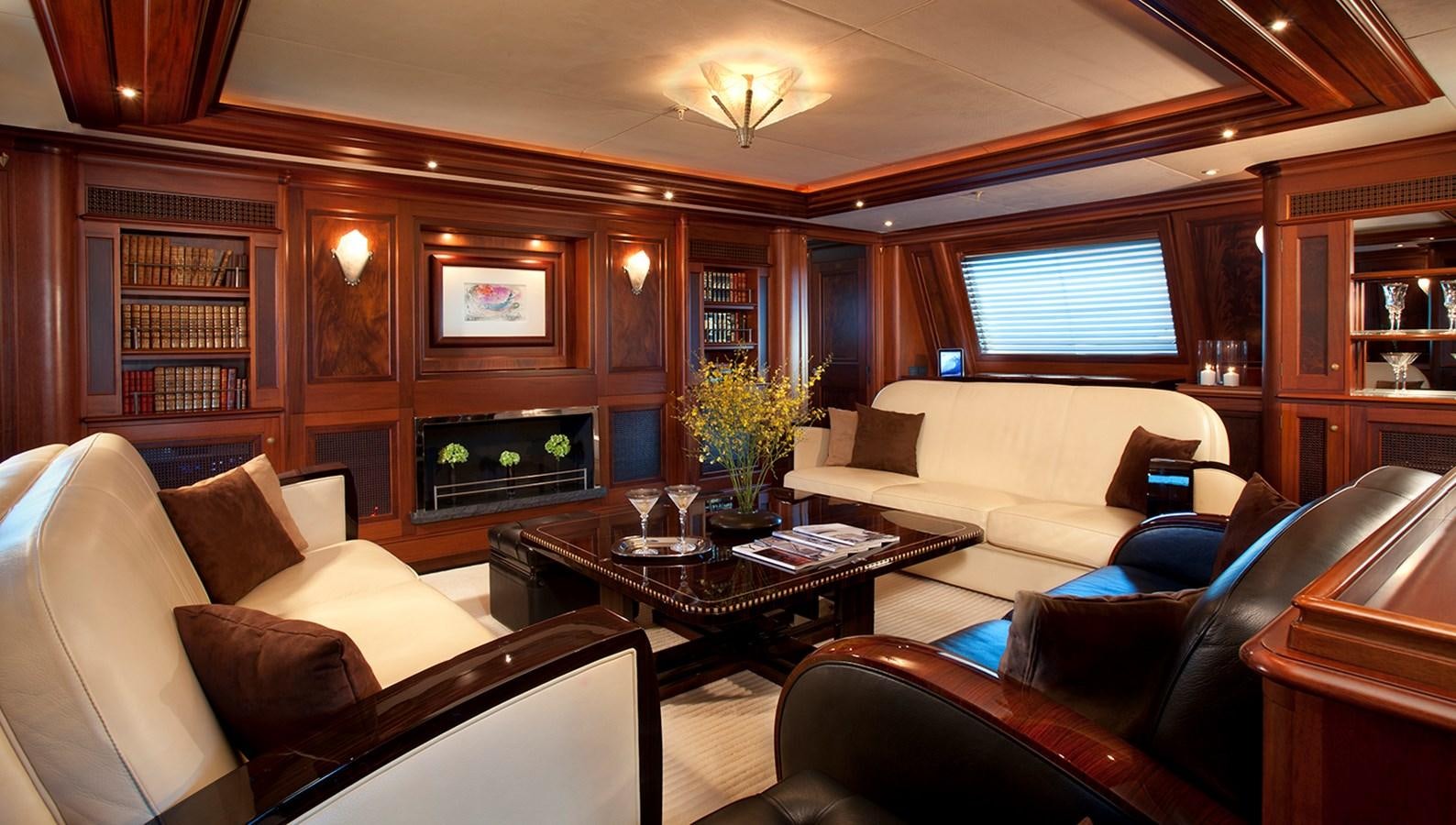 a living room with leather couches and a fireplace aboard TIARA II Yacht for Sale