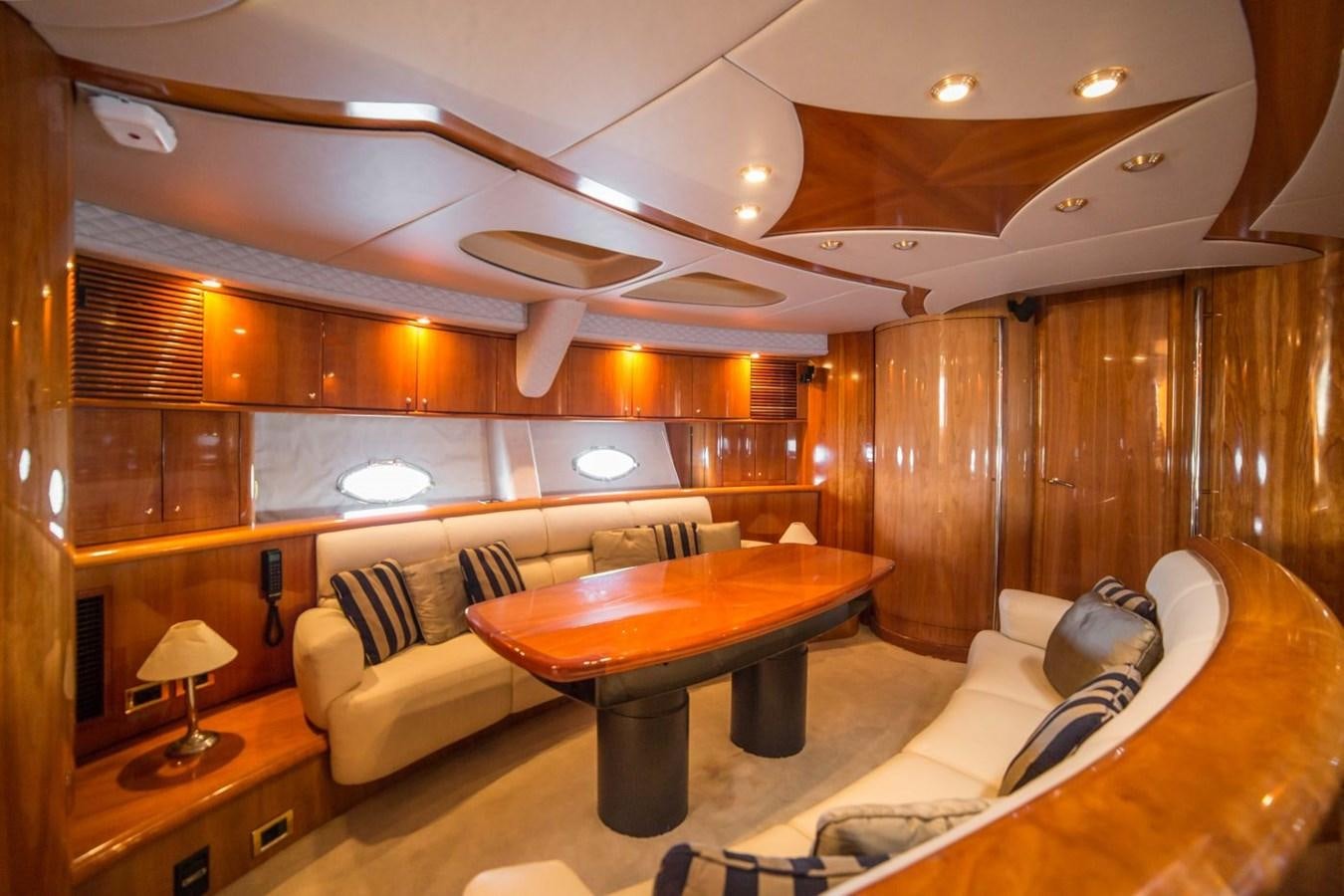 a room with a table and couch aboard LE CHIFFRE Yacht for Sale