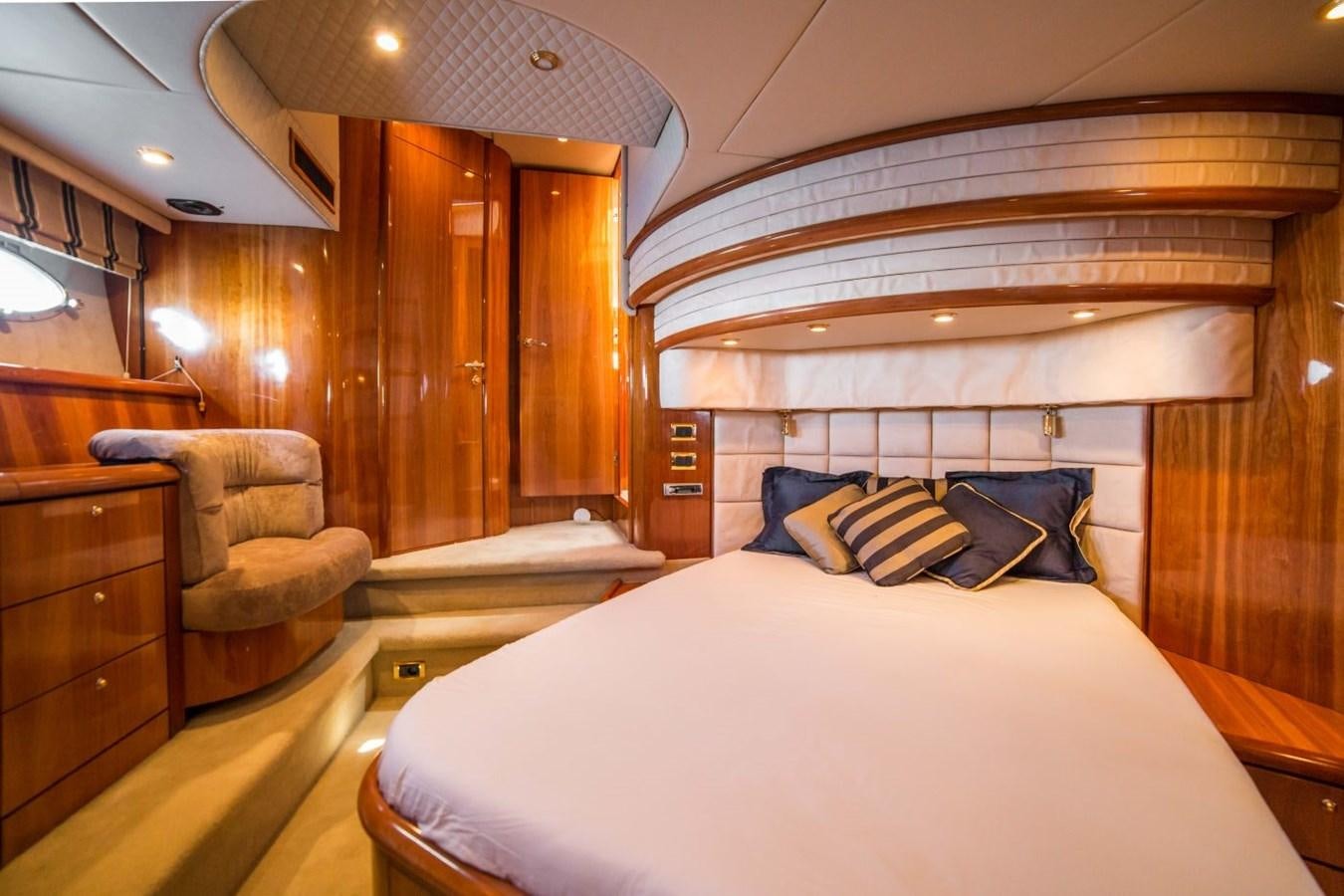 a bedroom with a bed and a chair aboard LE CHIFFRE Yacht for Sale