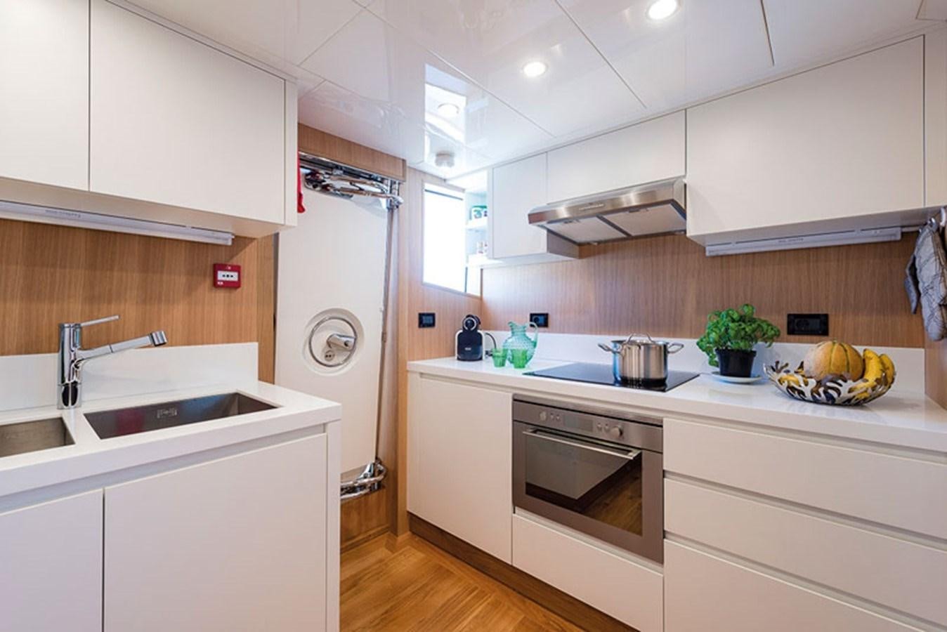 a kitchen with white cabinets aboard UNICA Yacht for Sale