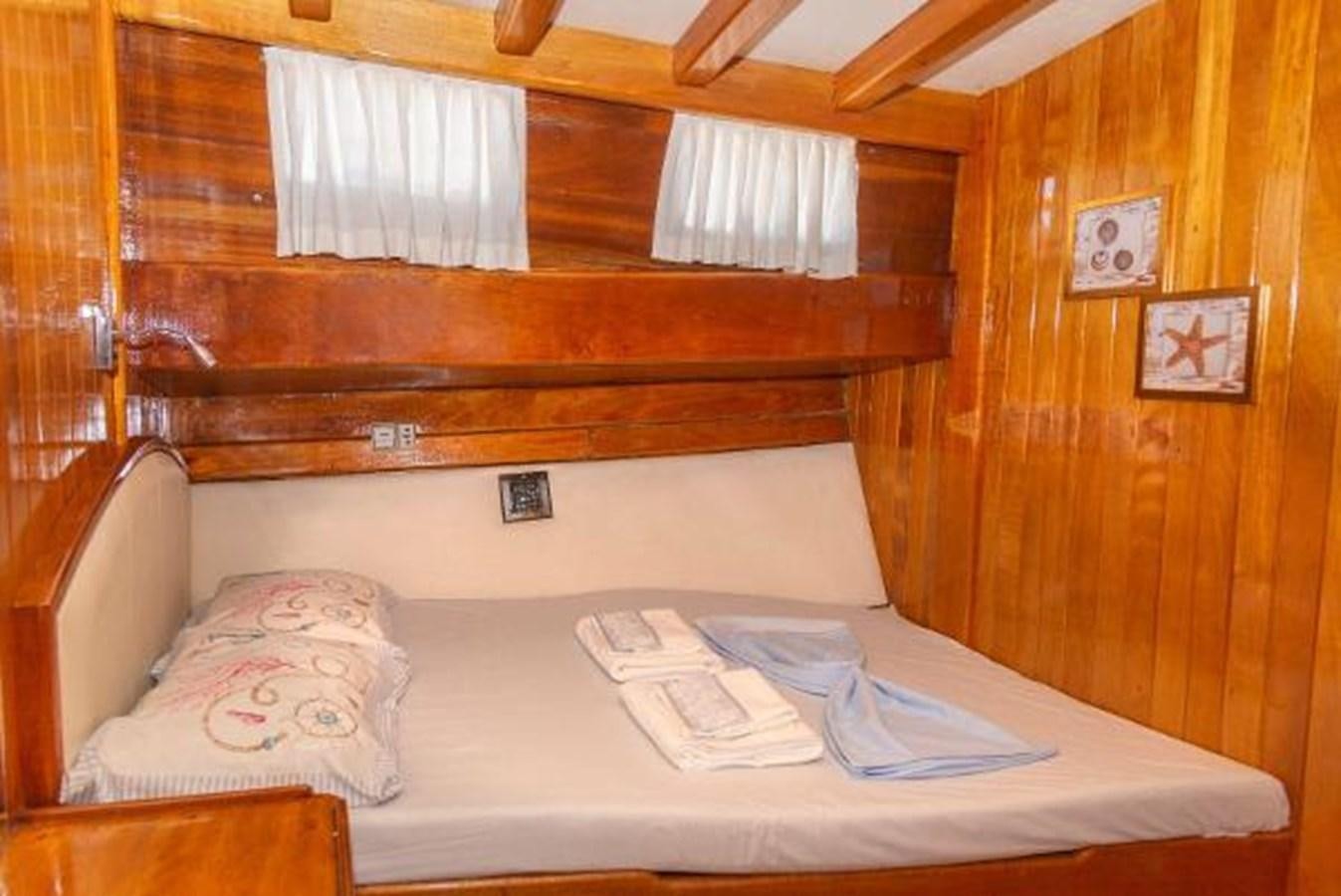 a bed with a white sheet and a white pillow on it aboard 1998 CUSTOM SAILING YACHT Yacht for Sale