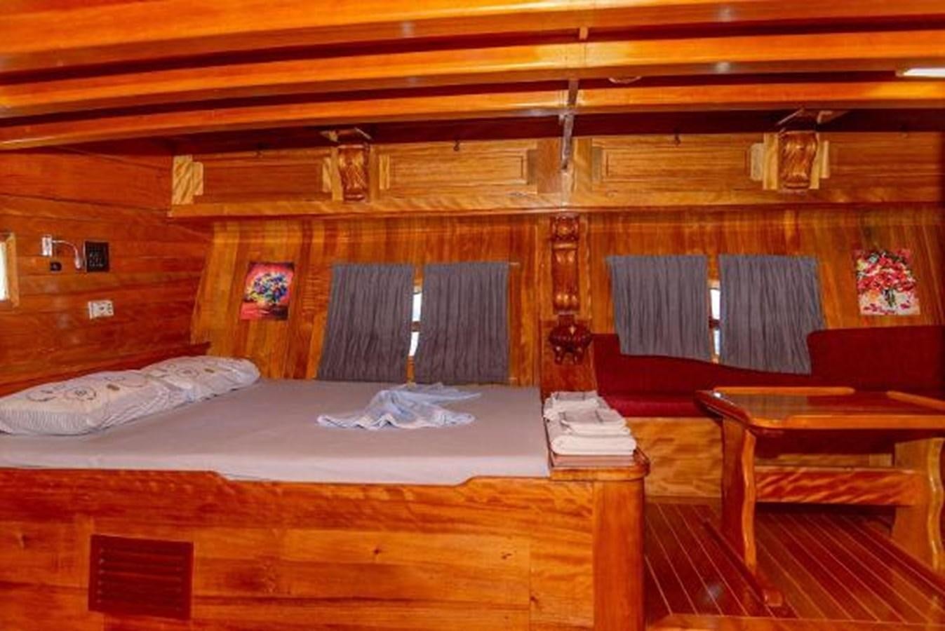 a bed with a white sheet and a wooden wall aboard 1998 CUSTOM SAILING YACHT Yacht for Sale