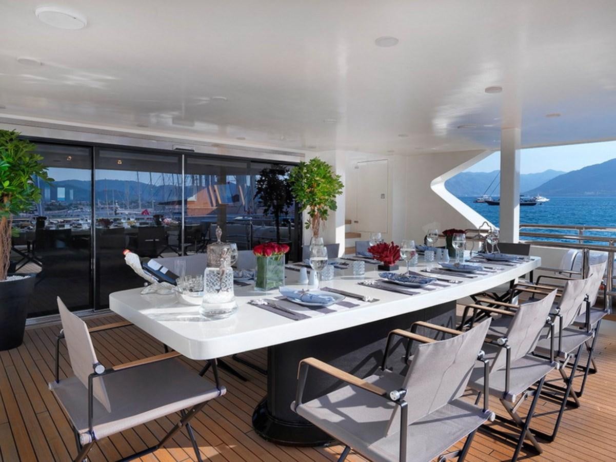 a table with chairs and a large umbrella aboard QUEEN MARE Yacht for Charter