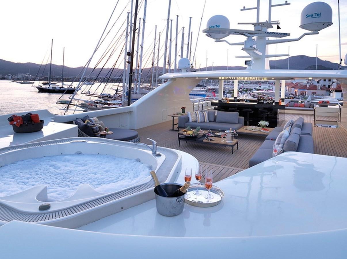 a table with a couple of white plates and a black bucket on it aboard QUEEN MARE Yacht for Charter