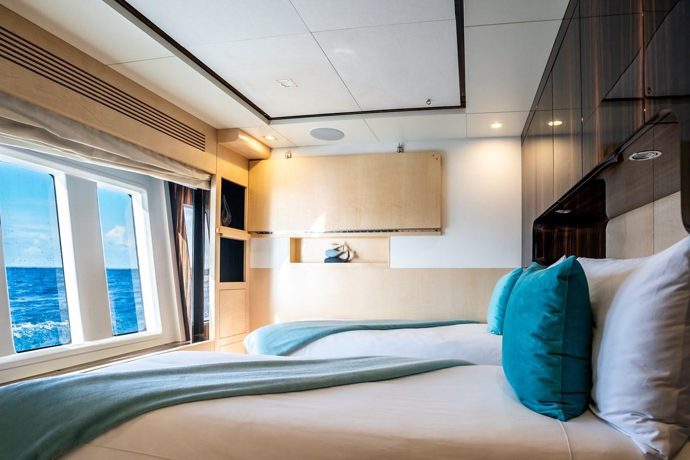 a bed with blue pillows aboard Valere Yacht for Sale