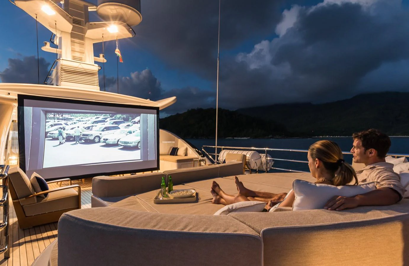 a couple sitting on a couch watching a tv aboard LILI Yacht for Charter