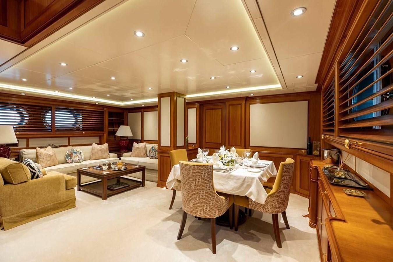a large living room with a dining table and couches aboard NORFOLK STAR Yacht for Charter