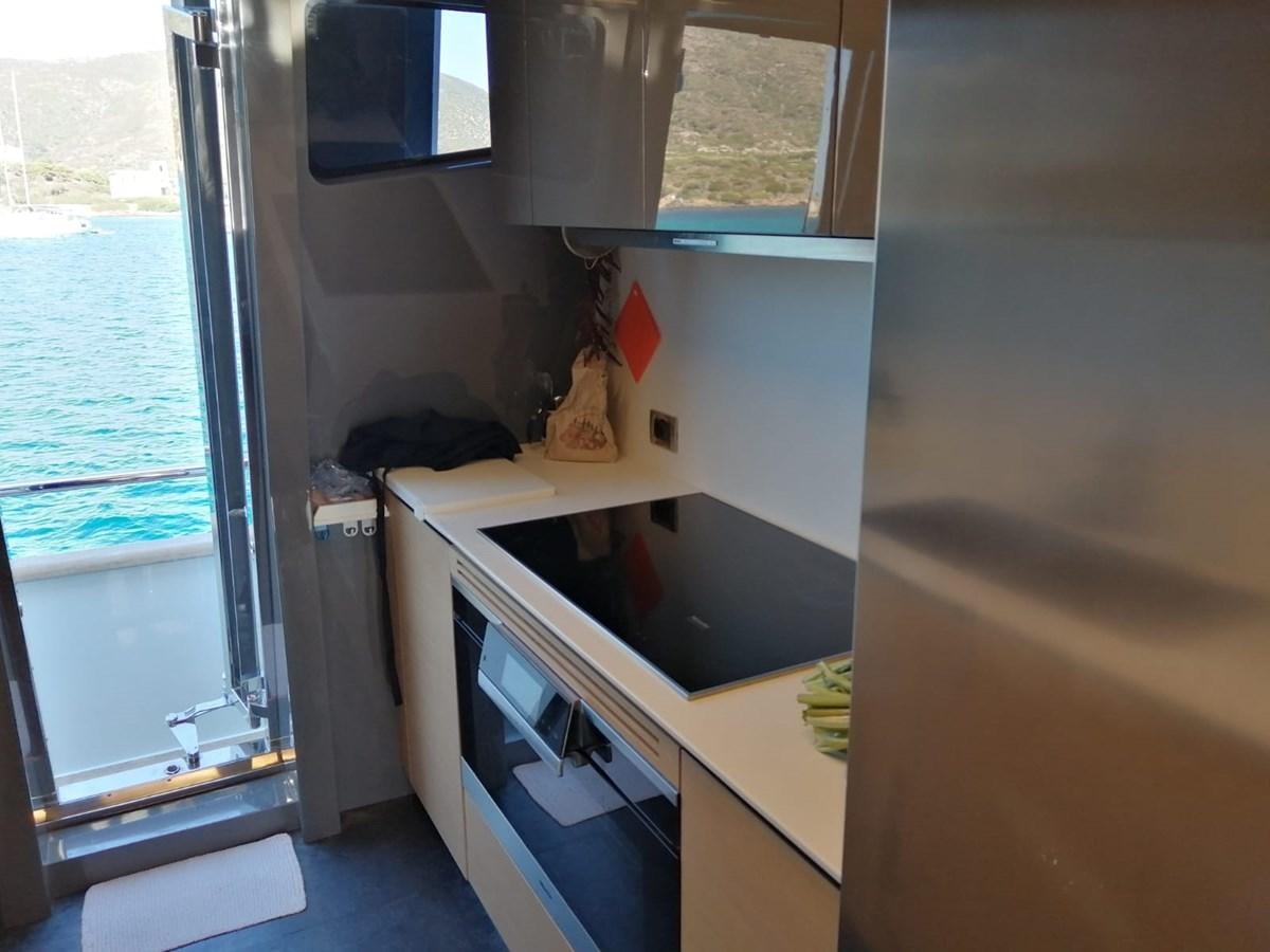 a small kitchen with a sliding glass door aboard VISIONARIA Yacht for Sale