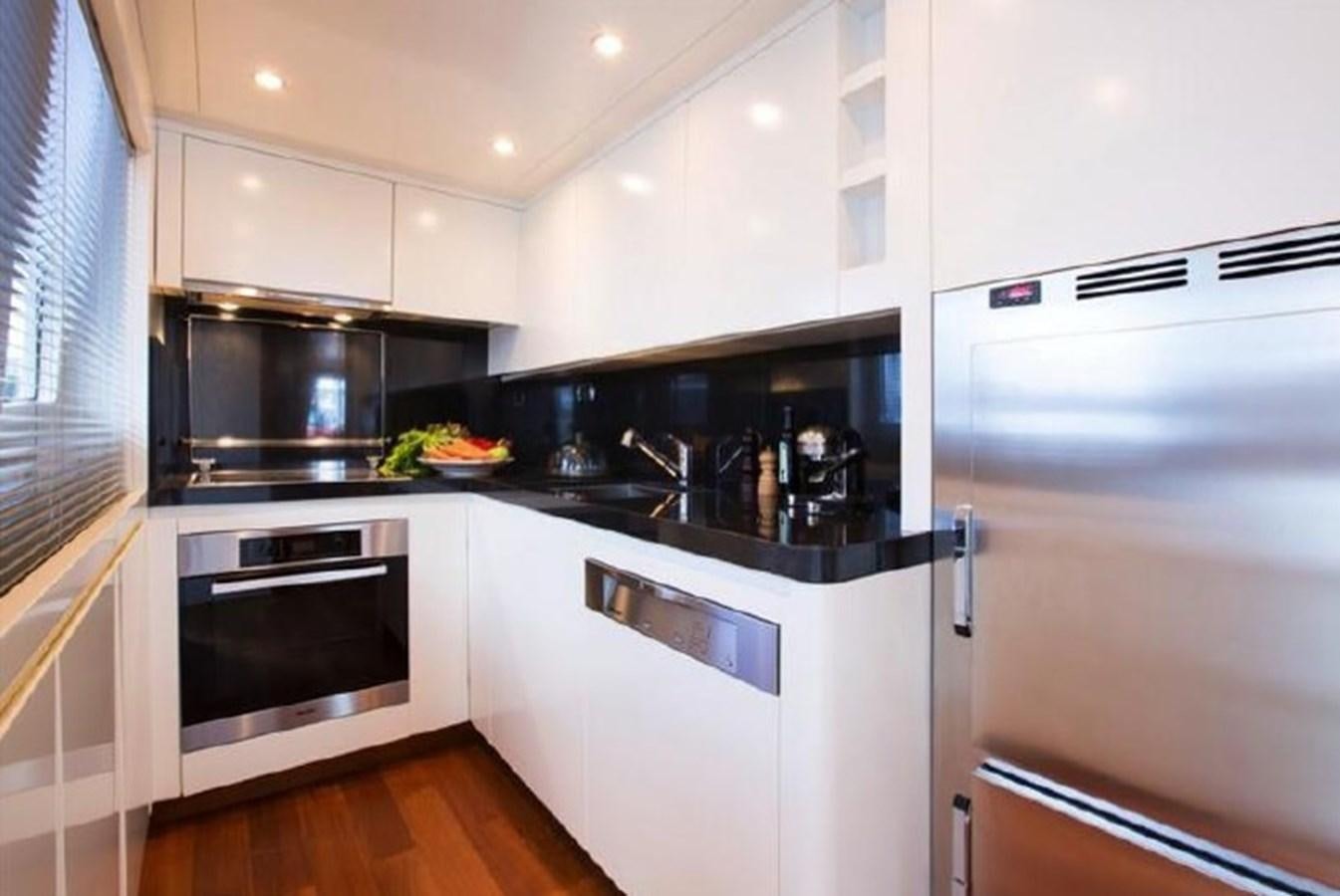 a kitchen with white cabinets aboard M.C Yacht for Sale