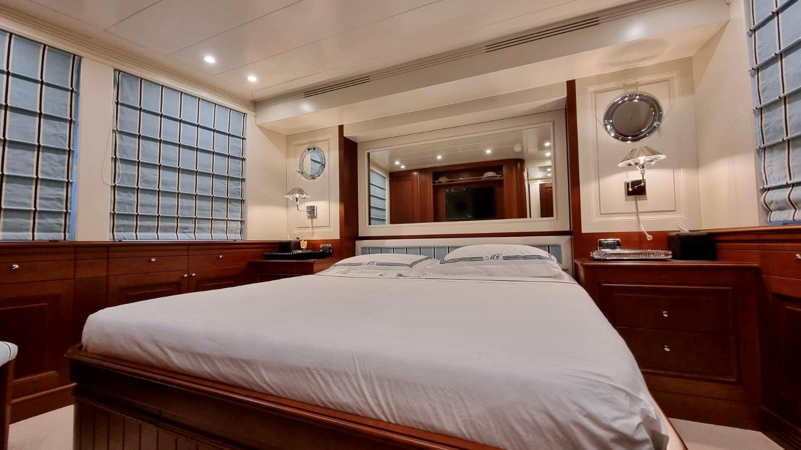 a room with a bed and a mirror aboard M.C Yacht for Sale