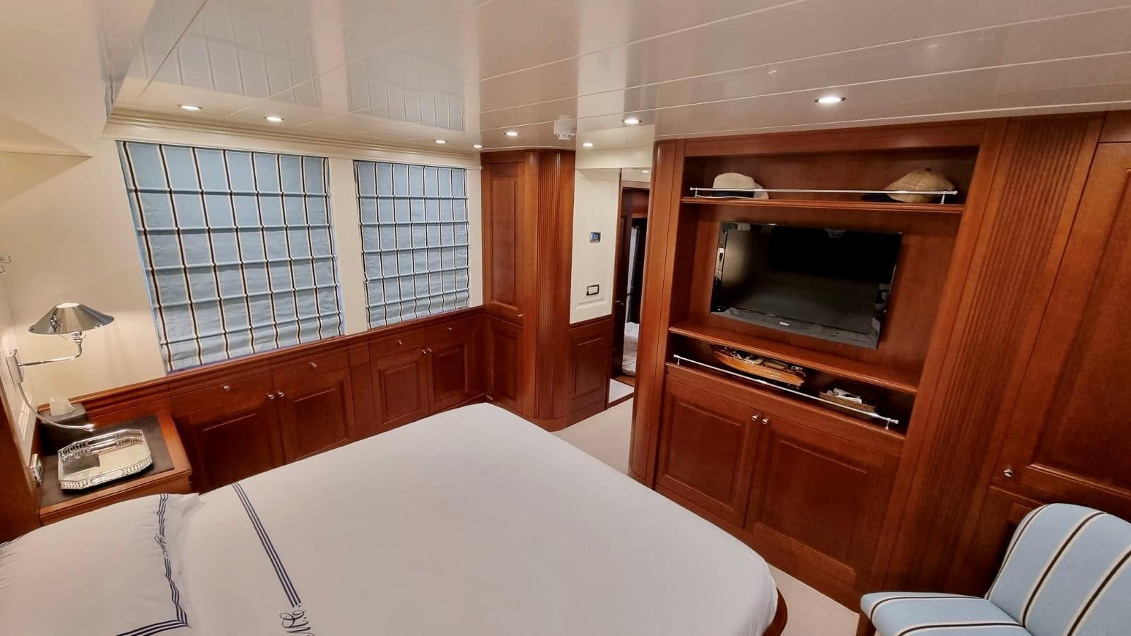 a room with a bed and a television aboard M.C Yacht for Sale
