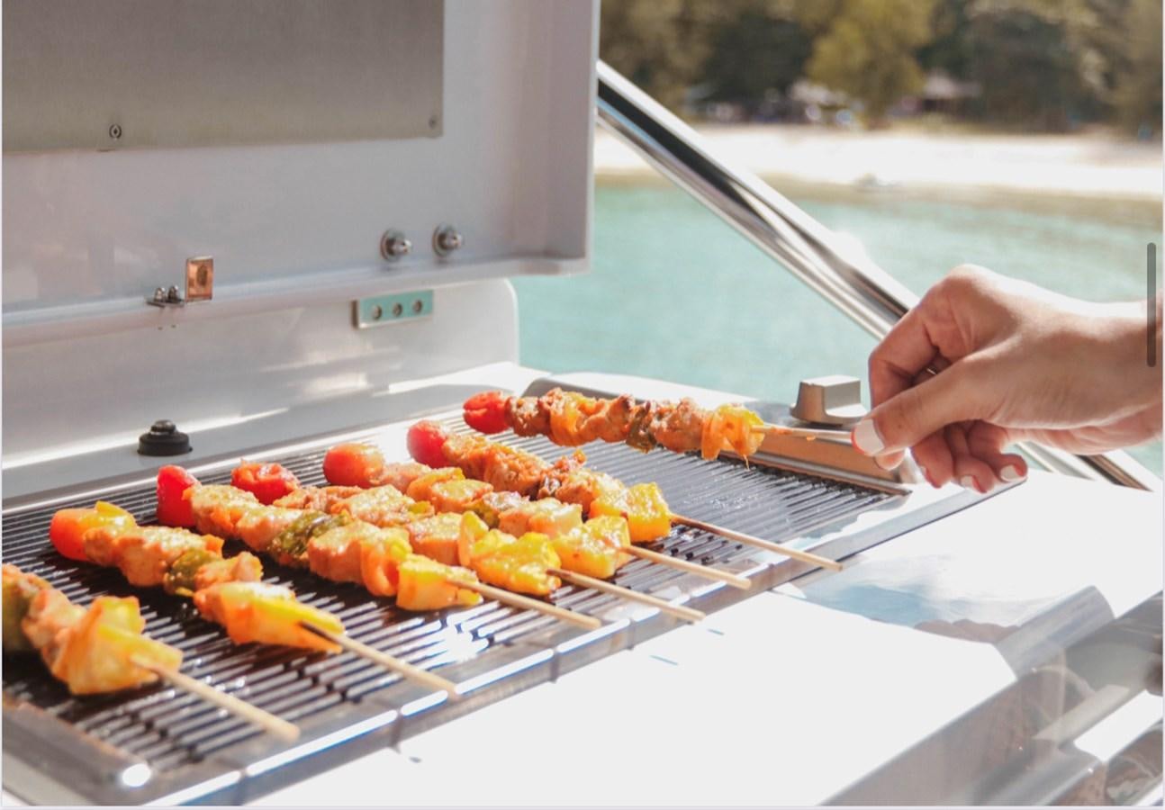 a person cooking food on a grill aboard FARA Yacht for Sale