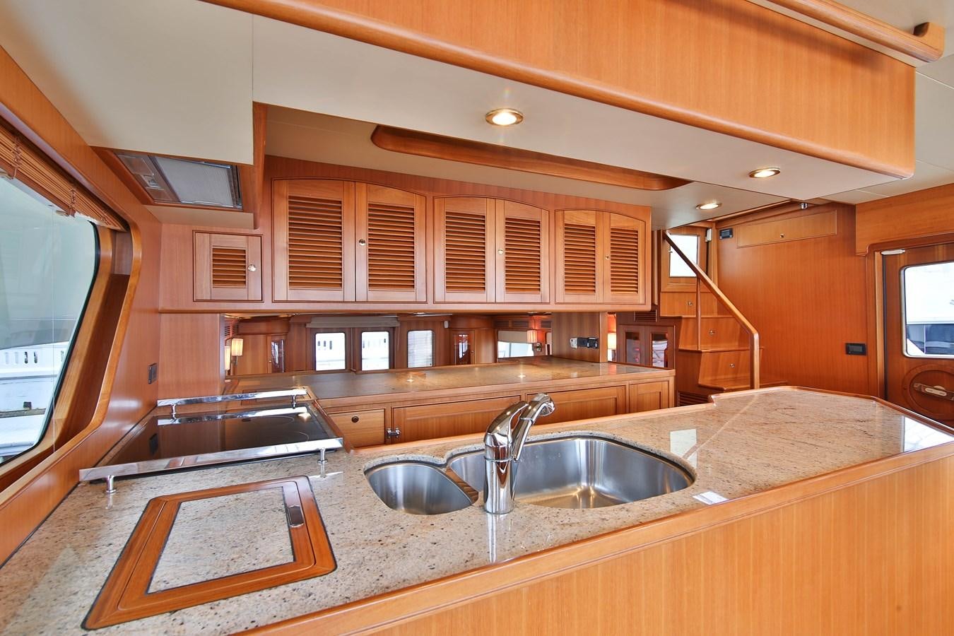 a kitchen with wooden cabinets aboard FREQUENT SEA Yacht for Sale