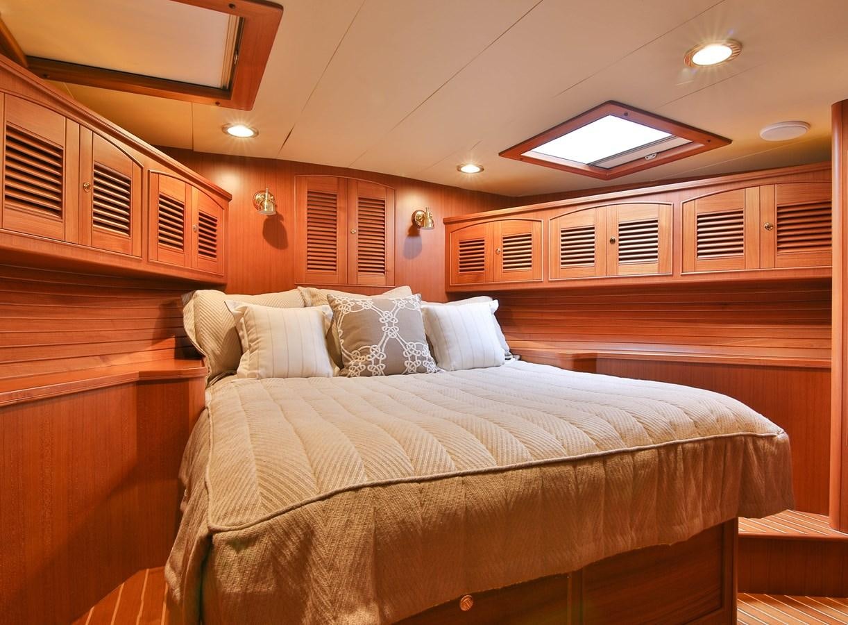a bed with a white comforter aboard FREQUENT SEA Yacht for Sale
