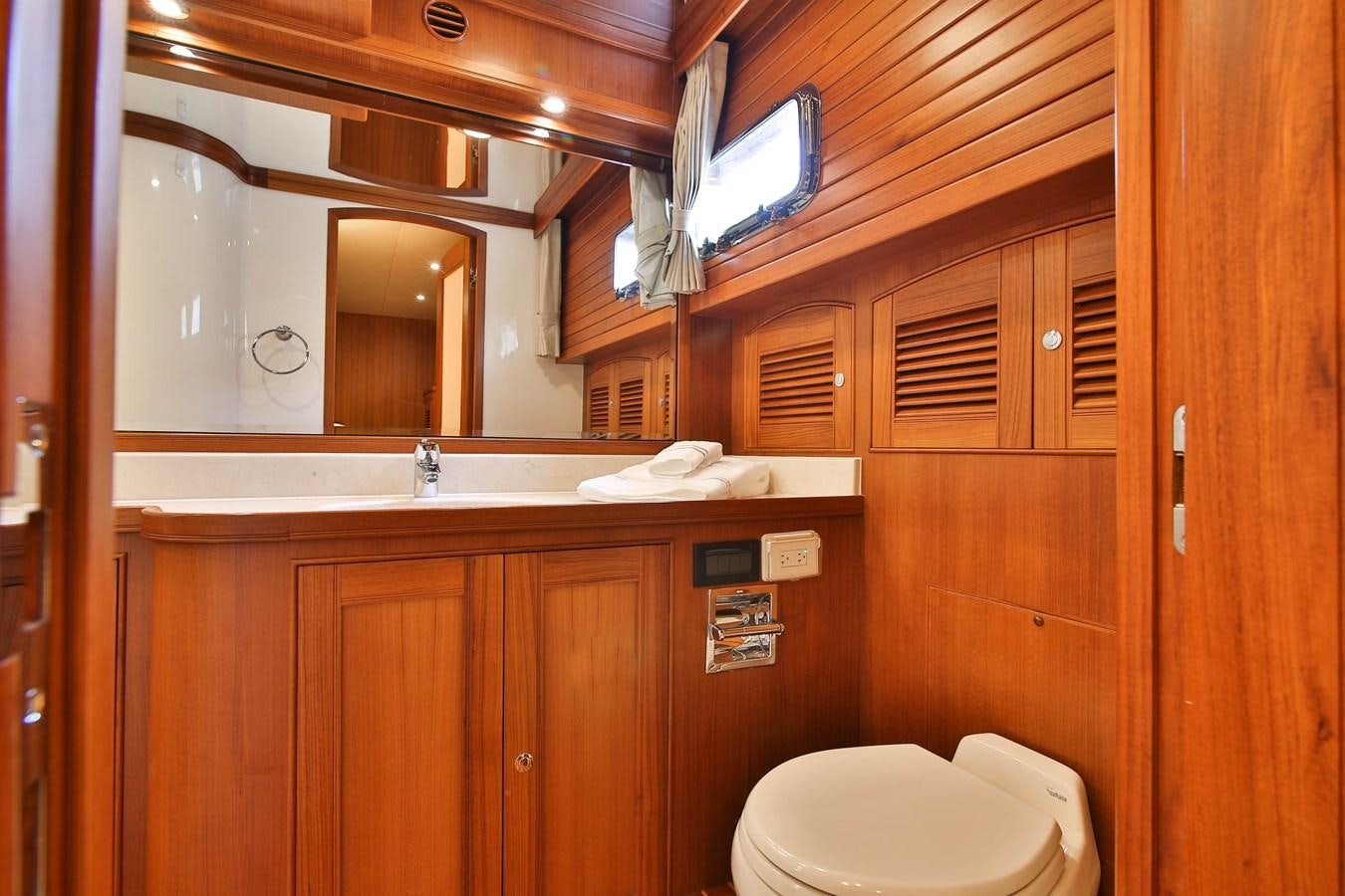 a bathroom with wooden cabinets aboard FREQUENT SEA Yacht for Sale