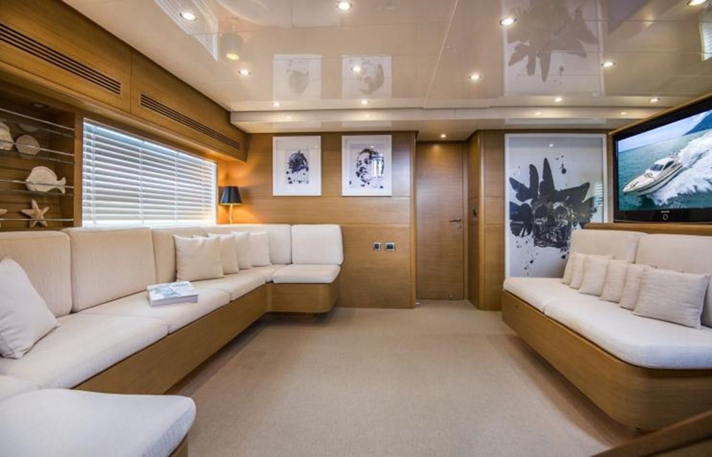 a living room with a large couch and a tv aboard FB Yacht for Sale