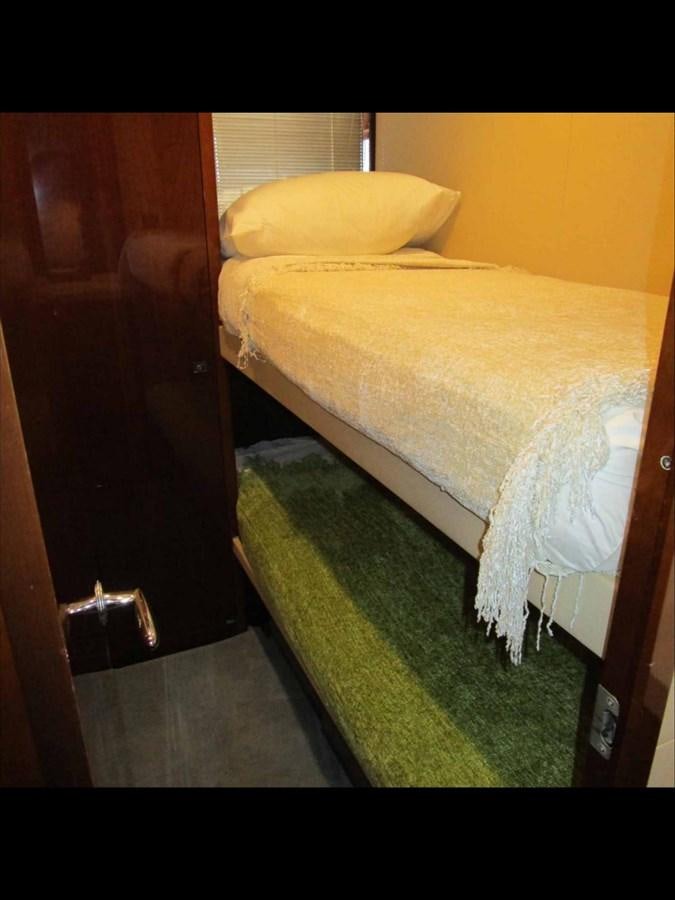 a bed with a green rug aboard MOJO II Yacht for Sale