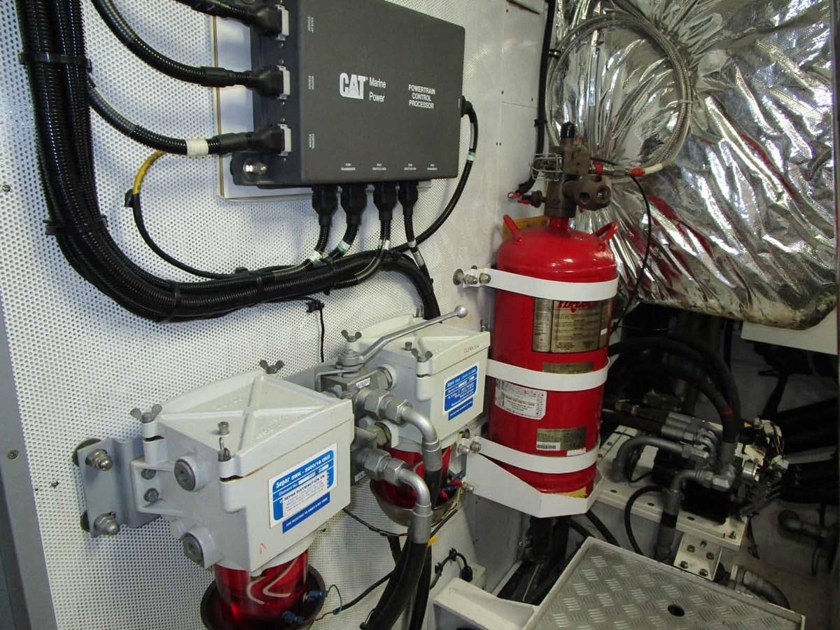 a white and red fire extinguisher on a white wall aboard MOJO II Yacht for Sale