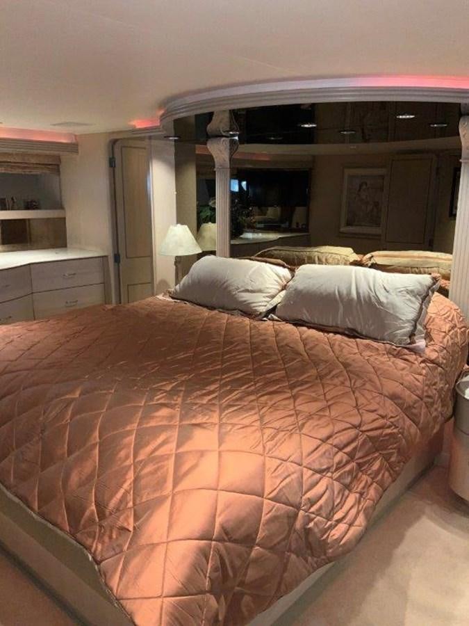 a bed with a red comforter aboard LADY GRACE Yacht for Sale