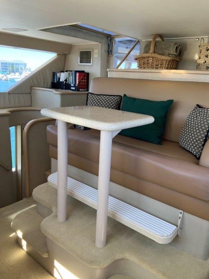 a white table with a blue pillow on it aboard LADY GRACE Yacht for Sale