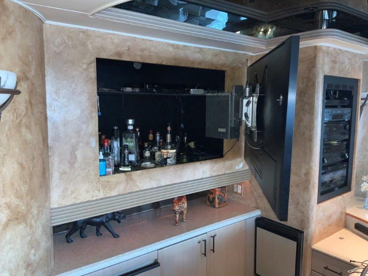 a large room with a bar and a shelf with bottles and a shelf aboard LADY GRACE Yacht for Sale