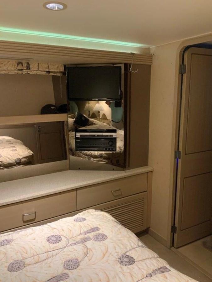 a small bedroom with a bed and a television aboard LADY GRACE Yacht for Sale