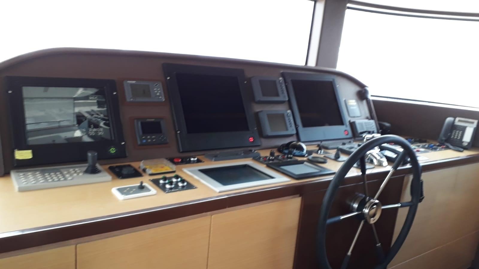 a desk with computers and monitors aboard MR. GU Yacht for Sale