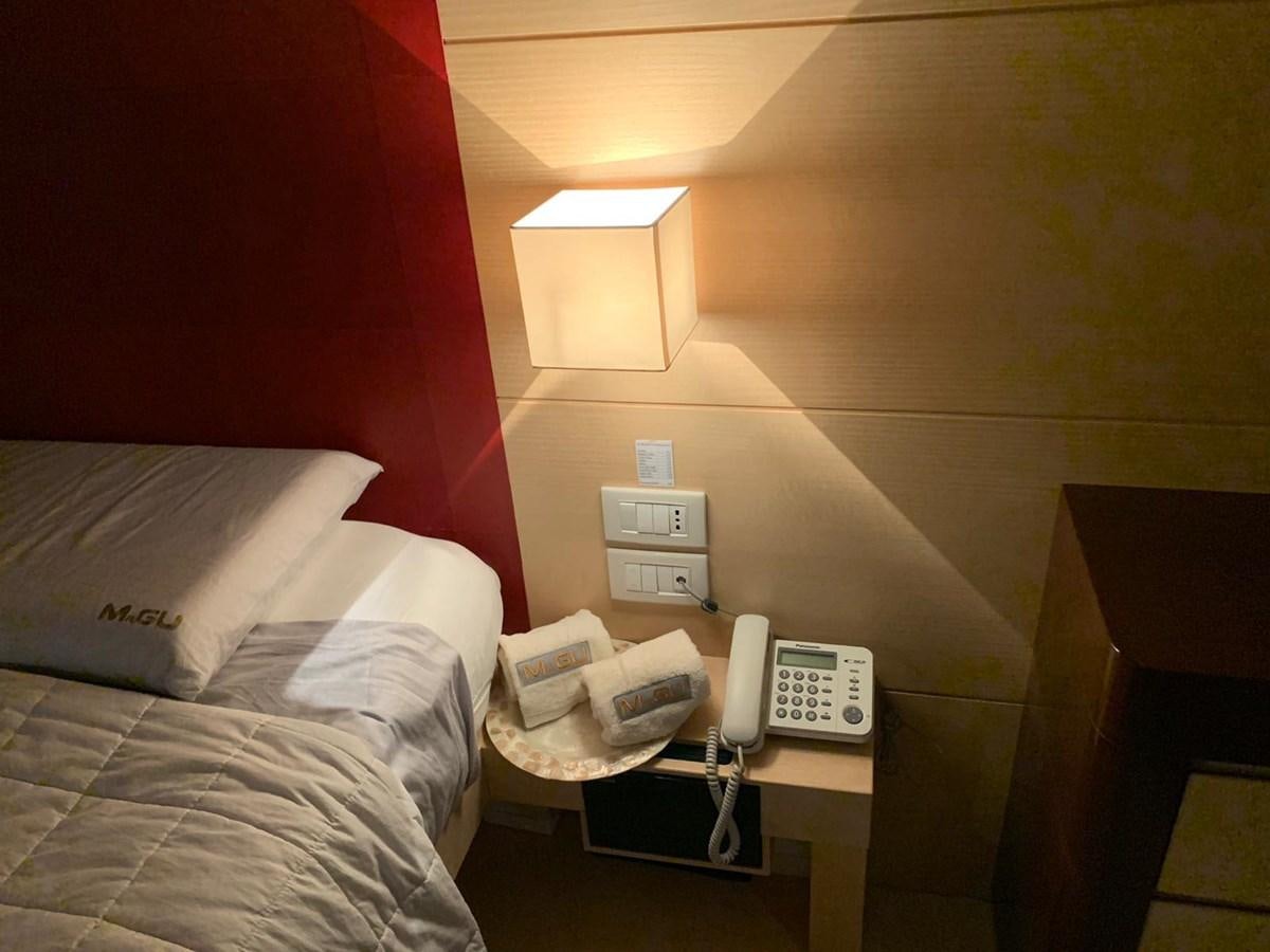 a hotel room with a phone and a bed aboard MR. GU Yacht for Sale