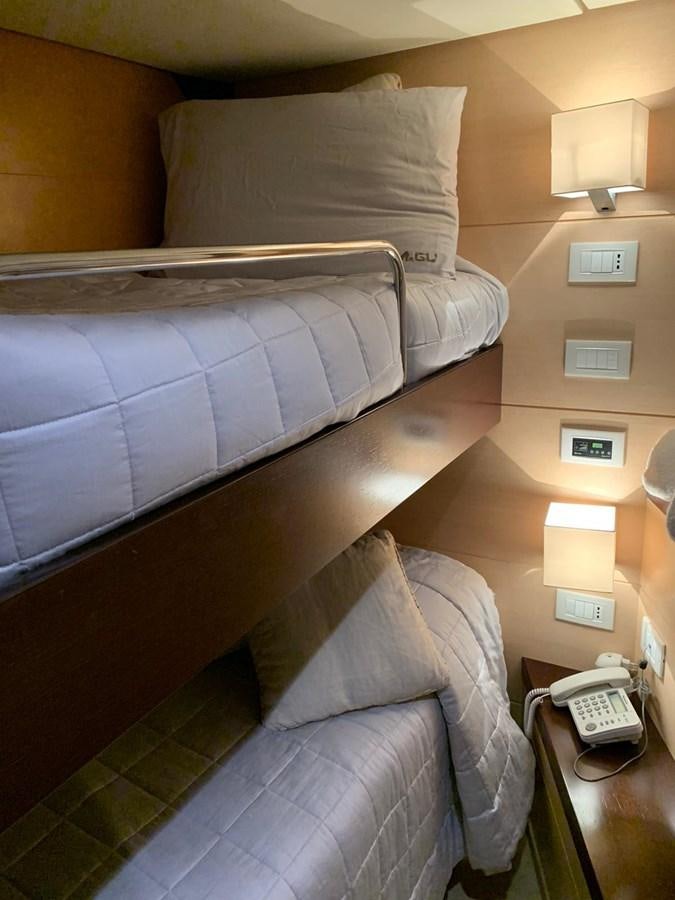a bed with a pillow and a phone on it aboard MR. GU Yacht for Sale