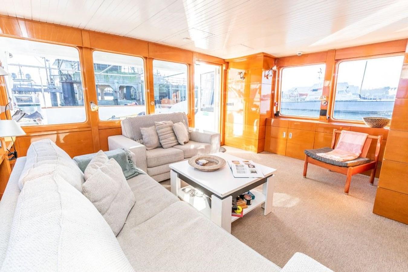 a living room with a couch and a coffee table aboard HISTORY Yacht for Sale