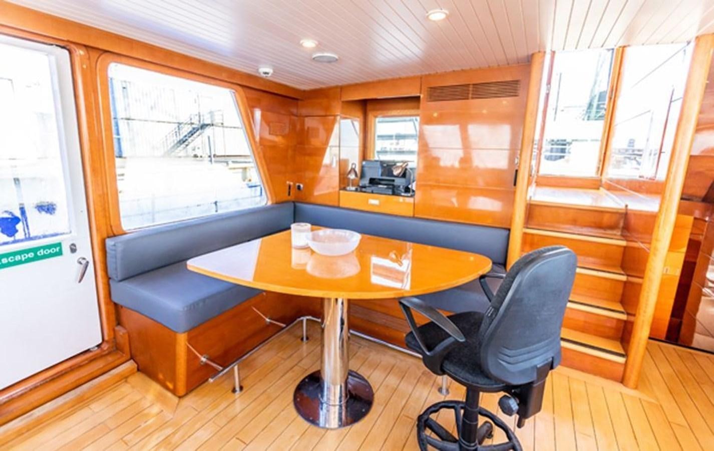 a room with a table and chairs aboard HISTORY Yacht for Sale