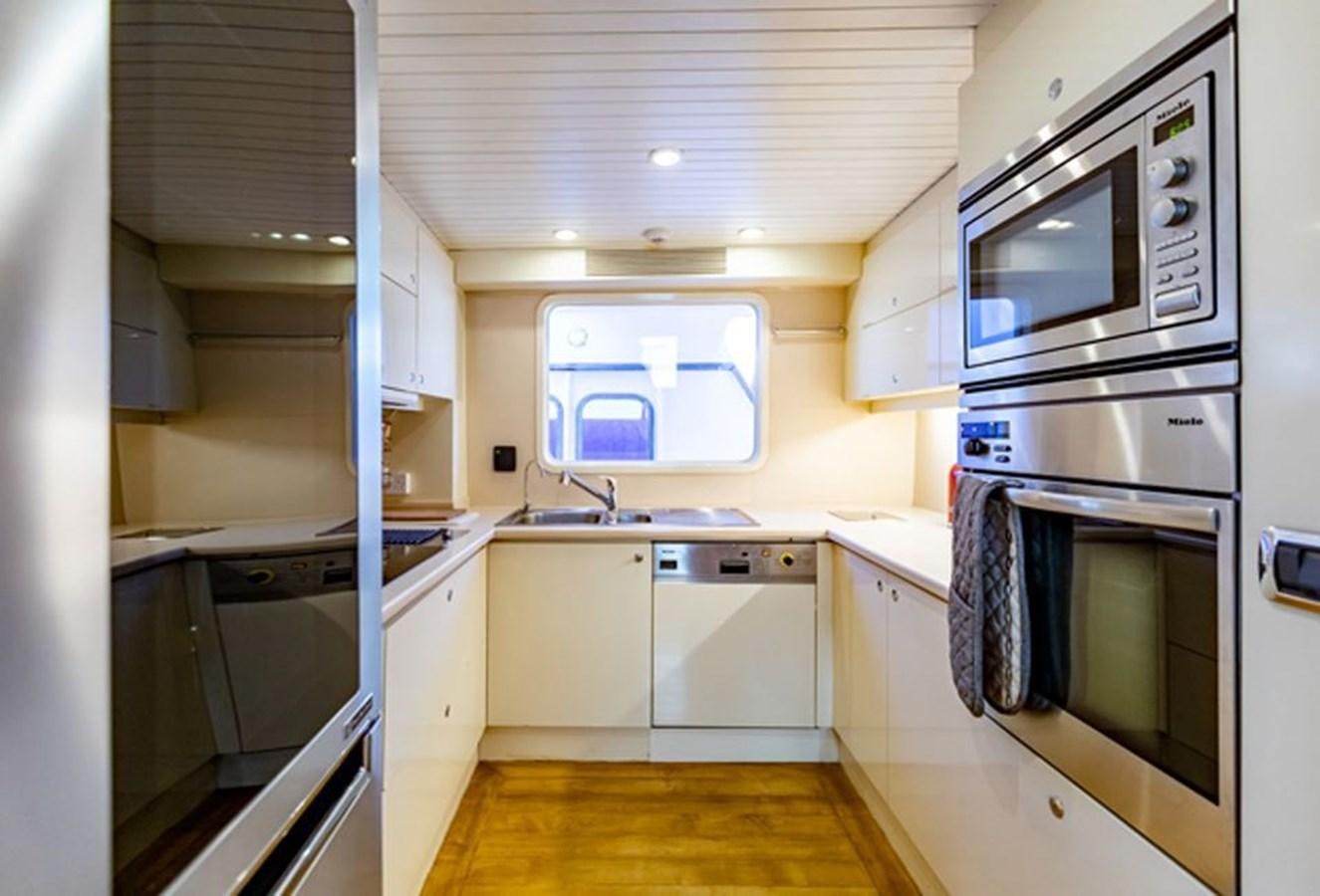 a kitchen with white cabinets aboard HISTORY Yacht for Sale