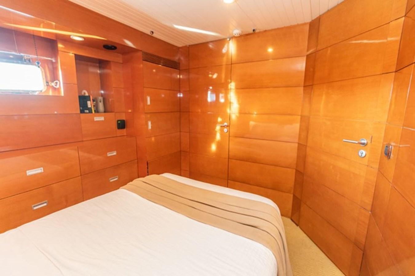 a room with a bed and a wooden wall aboard HISTORY Yacht for Sale