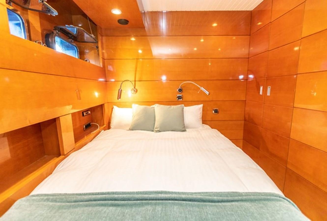 a bed with a white sheet and pillows aboard HISTORY Yacht for Sale
