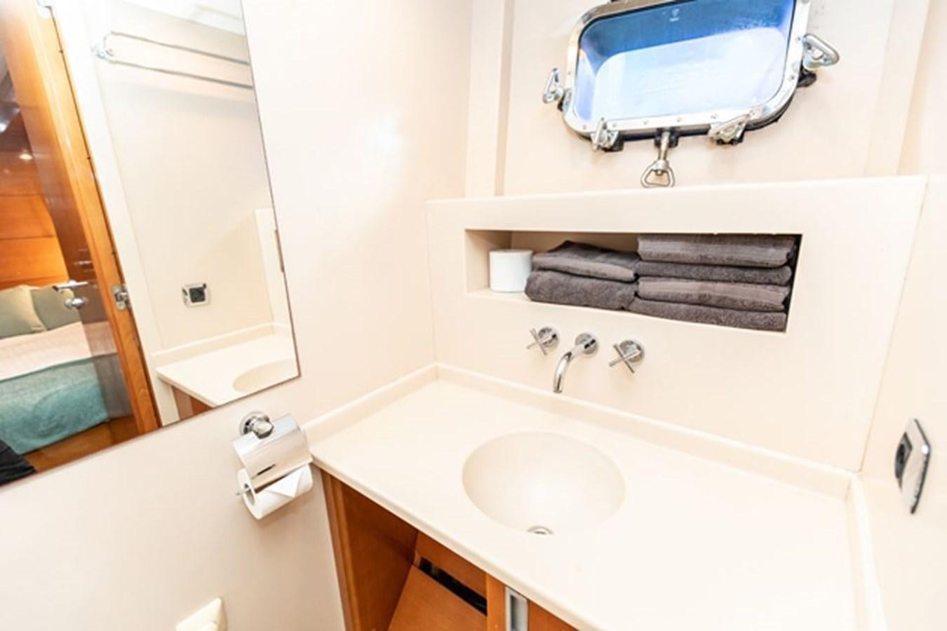 a bathroom with a sink and a mirror aboard HISTORY Yacht for Sale