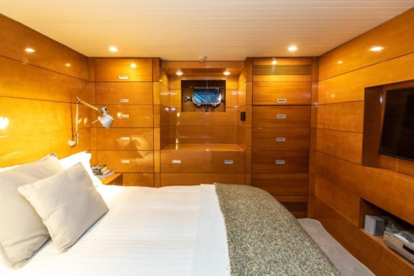 a bed with a white sheet and a wooden wall aboard HISTORY Yacht for Sale