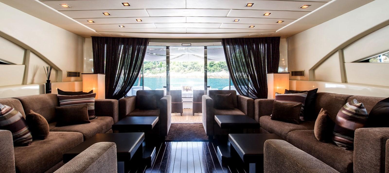 a living room with leather couches and a large glass window aboard BLOOMS Yacht for Charter