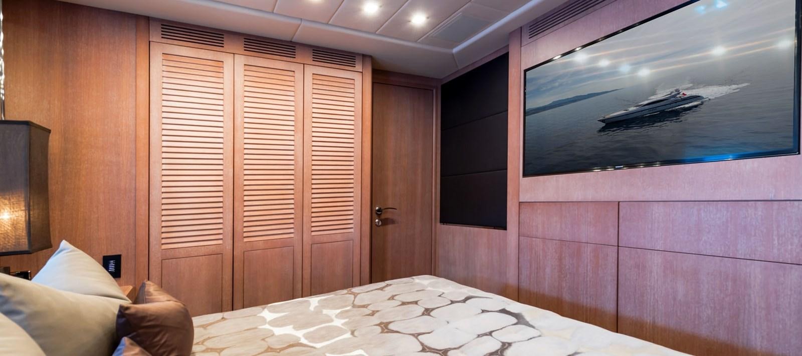 a room with a bed and a television aboard BLOOMS Yacht for Charter