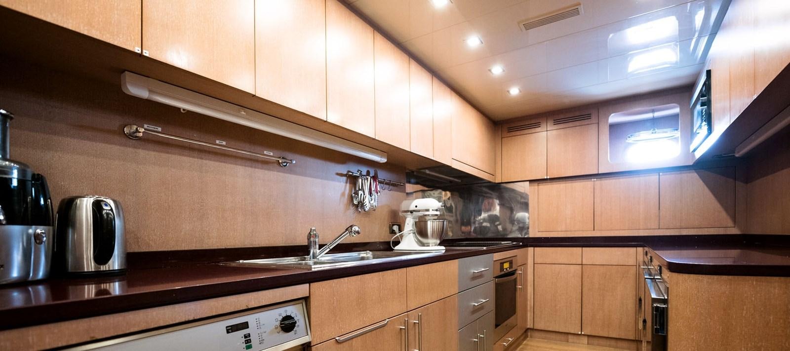 a kitchen with wooden cabinets aboard BLOOMS Yacht for Charter