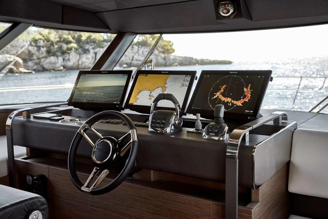 a table with laptops and headphones on it aboard 2022 PRESTIGE X70 #09 Yacht for Sale